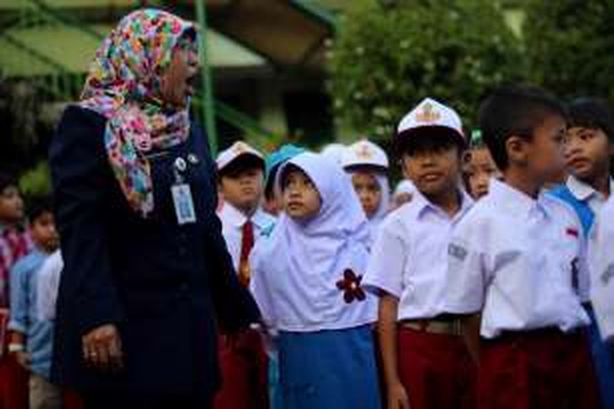 Anak-anak berbaris mengikuti upacara bendera pada hari pertama masuk sekolah di SDN 01 Menteng, Jakarta Pusat, Senin (18/7/2016).  Peraturan Menteri Pendidikan dan Kebudayaan Nomor 23 Tahun 2015 tentang Penumbuhan Budi Pekerti berisi, antara lain, tentang keterlibatan orangtua dalam pendidikan anak. Salah satu hal yang ditekankan ialah kewajiban orangtua mengantar anak ke sekolah pada hari pertama tahun ajaran baru.
