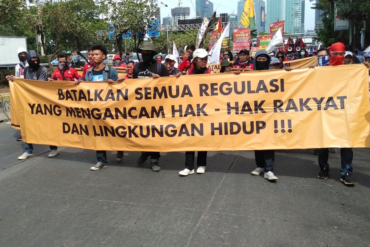 Massa aksi dari kelompok buruh lakukan long march ke gedung DPR RI, Senayan, Jakarta Pusat, Senin (30/9/2019).