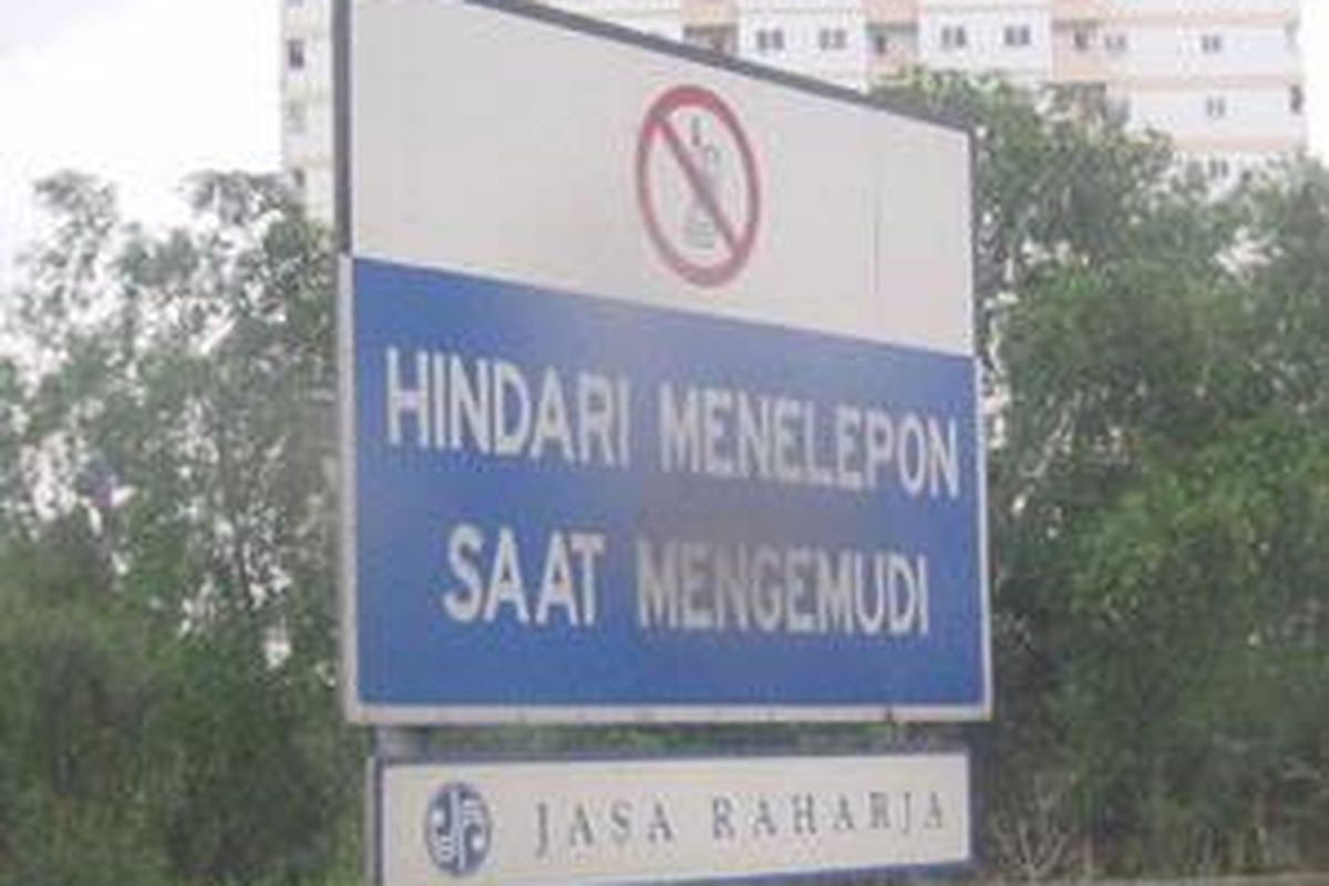 Reklame untuk menghindari pemakaian telepon saat berkendaraan yang dipasang pada sisi jalan tol harus tetap diperhatikan, meskipun teknologi telah semakin memudahkan.