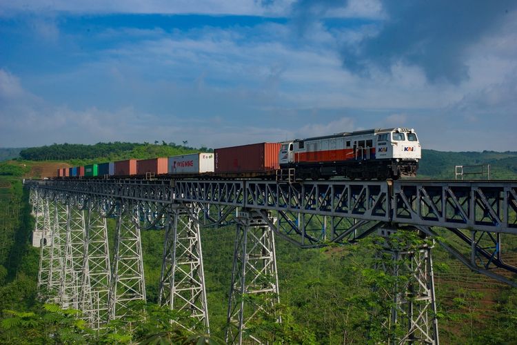 Lokomotif CC206 dari PT Kereta Api Indonesia (KAI) melintasi jembatan.