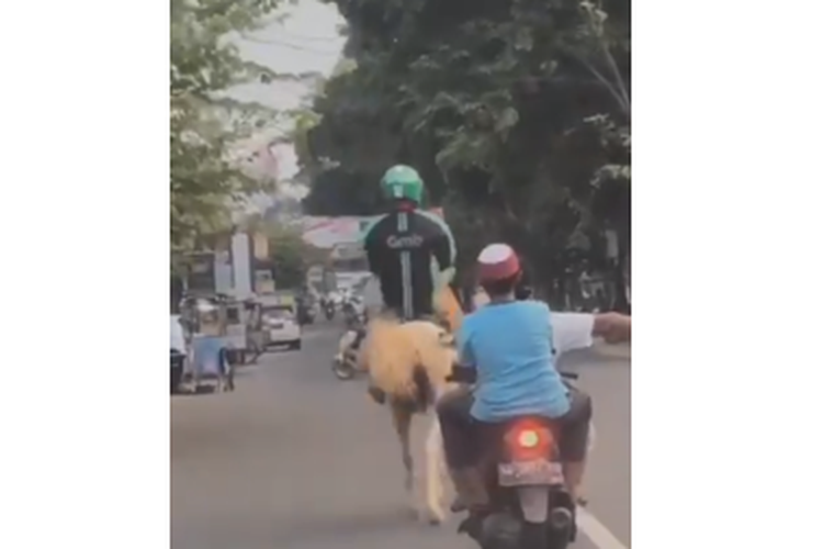 Tangkapan layar video driver ojek online tengah berkuda di jalan raya di daerah Surakarta.