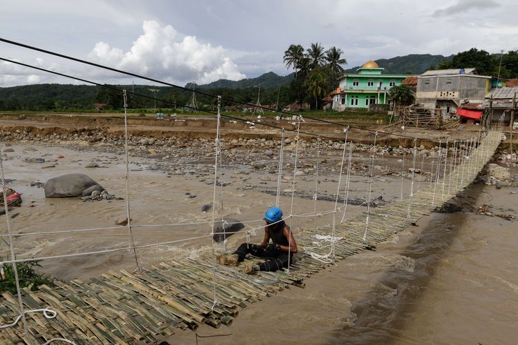 Relawan Paguyuban Pedagang Outdoor Bandung membangun jembatan darurat di atas Sungai Cidurian, Kampung Ciasahan, Desa Sukamaju, Kecamatan Cigudeg, Kabupaten Bogor, Senin (13/1/2020). Pasca banjir bandang yang menerjang lokasi ini, Rabu (1/1/2020) kemarin memutuskan jembatan yang menjadi akses ke sekolah As-Sarbini.