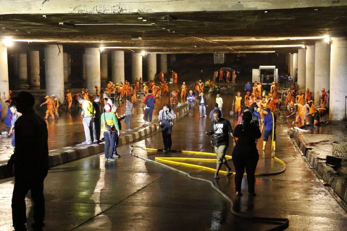 Banjir yang menggenangi Underpass Gandhi, Kemayoran, Jakarta Pusat, surut pada Minggu (26/1/2020) malam. Petugas Pemprov DKI Jakarta tampak membersihkan underpass tersebut.