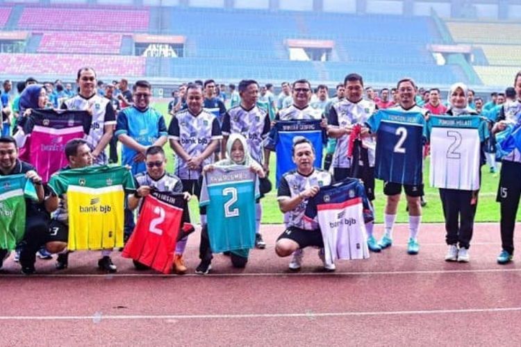 Foto sejumlah aparatur sipil negara (ASN) memamerkan jersey bernomor dua usai kegiatan pertandingan sepak yang melibatkan seluruh jajaran aparatur se-Kota Bekasi di Stadion Patriot Chandrabaga. 