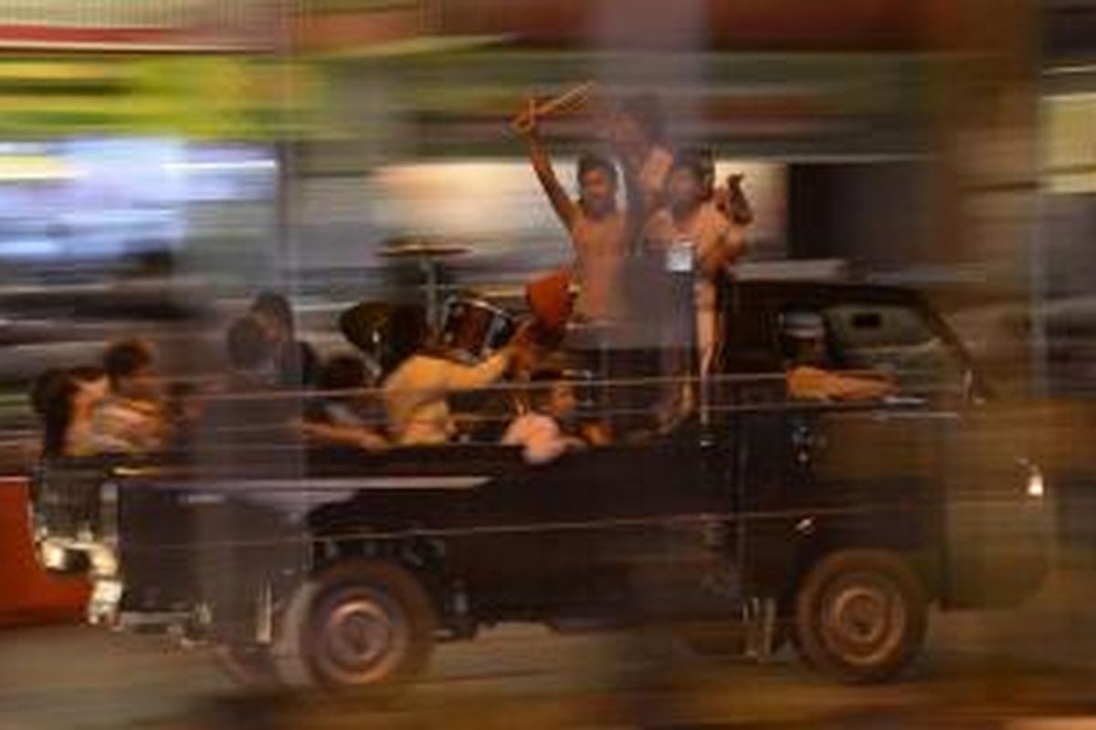 Sejumlah peserta pawai bersuka cita di atas kendaraan bak terbuka saat mengikuti pawai takbiran di Jalan Jenderal Sudirman, Balikpapan, Rabu (7/8/2013). 