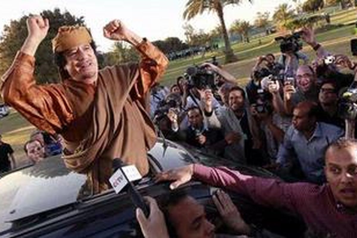 Libyan leader Muammar Gaddafi waves from a car in the compound of Bab Al Azizia in Tripoli, after a meeting with a delegation of five African leaders seeking to mediate in Libyas conflict in this April 10, 2011 file photo. A war crimes prosecutor on May 16, 2011 sought an arrest warrant for Muammar Gaddafi, accusing him of killing protesters against his four-decade rule, as NATO stepped up strikes on Libyan forces. Picture taken April 10, 2011.
