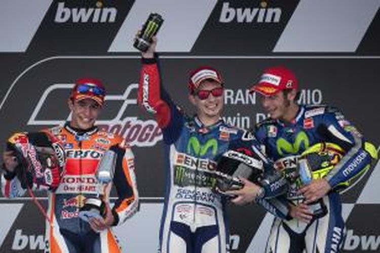 Pebalap Movistar Yamaha asal Spanyol, Jorge Lorenzo (tengah), merayakan kemenangan pada GP Spanyol di atas podium Sirkuit Jerez, bersama pebalap Repsol Honda asal Spanyol, Marc Marquez (kiri), yang finis kedua, serta pebalap Movistar Yamaha asal Italia, Valentino Rossi, yang finis ketiga, Minggu (3/5/2015).