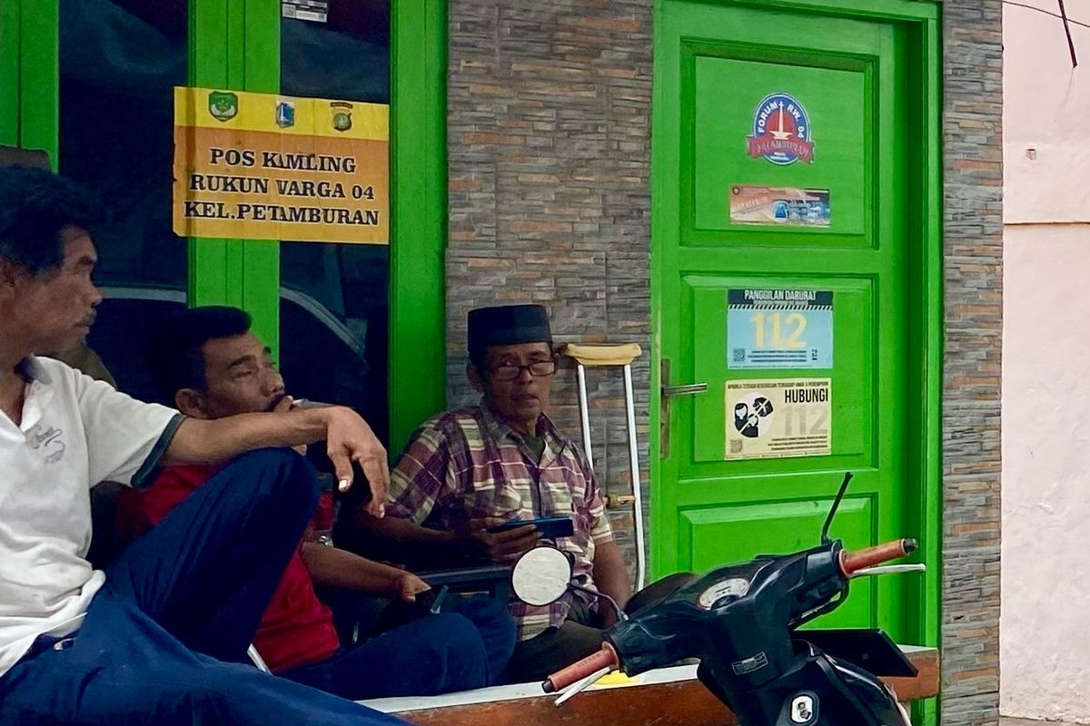 Tiga warga RW 04 Kelurahan Petamburan, Jakarta Pusat sedang duduk santai di depan Kantor RW 04, Kamis (15/2/2024).