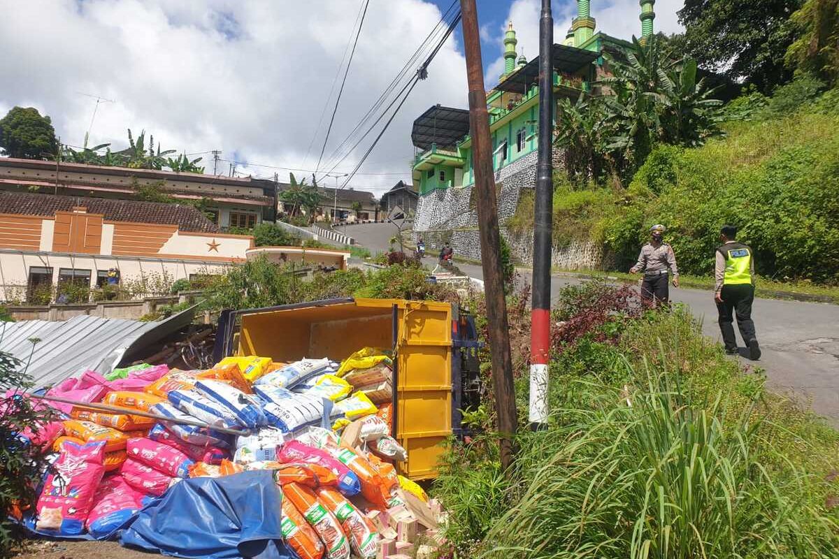 Belum pernah melintas di jalur maut Sarangan, sebuah truk bermuatan pakan kucing tergelincir dan menimpa sebuah warung dan sebuah motor.