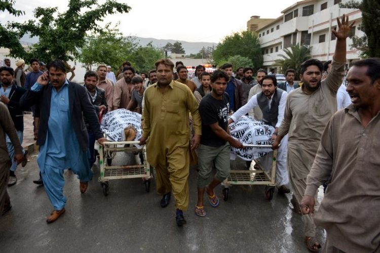 Warga Pakistan yang berduka mengarak dua jenazah yang ditembak mati oleh ISIS di luar gereja, di Quetta, Pakistan, Minggu (15/4/2018). (AFP/Banaras Khas)
