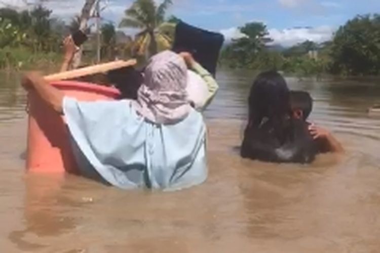 Banjir di Dusun Ballakajang, Desa Lembang-lembang,,Kecamatan Baebunta Selatan, Luwu Utara, Sulawesi Selatan, membuat warga mengungsi membawa barang mereka di tengah tingginya banjir, Selasa (23/4/2024) siang.