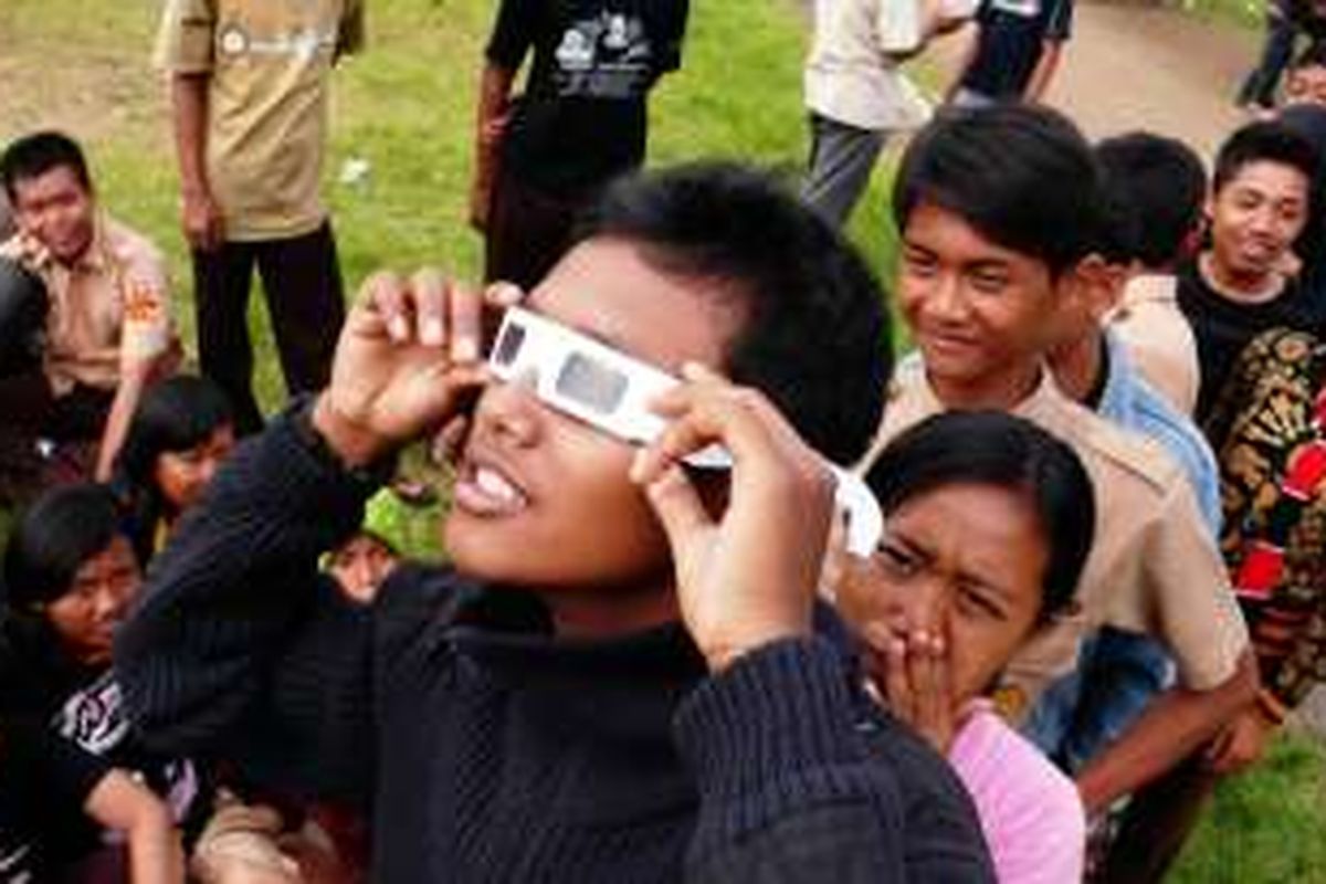 Sejumlah anak-anak mengantre menggunakan kacamata khusus untuk melihat gerhana saat pengamatan peristiwa gerhana matahari cincin terlihat jelas di Lapangan Sepakbola Universitas Lampung (Unila), Bandar Lampung, Lampung, Senin (26/1/2009).