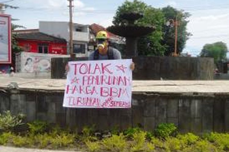Andre (37), warga Jalan Halmahera, Kelurahan Sumbersari, Kecamatan Sumbersari, Jember Jawa Timur, menggelar aksi tunggal, menolak kebijakan turunnya harga BBM, Jumat (16/1/2015).