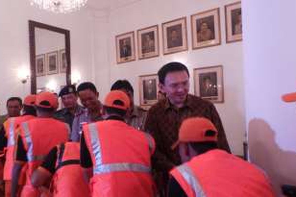 Gubernur DKI Jakarta Basuki Tjahaja Purnama terlihat bermaaf-maafan dengan petugas penanganan prasarana dan sarana umum (PPSU), saat halalbihalal di Balai Kota DKI Jakarta, Senin (11/7/2016).
