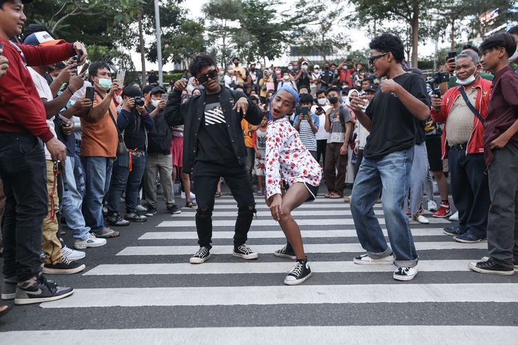 Roy (Citayam), Mami (Tanah Abang), dan Oman (Tanah Abang) memanfaatkan zebra cross untuk ajang unjuk pakaian di kawasan Dukuh Atas, Jakarta, Rabu (20/7/2022).  Fenomena Citayam Fashion Week di kawasan Dukuh Atas mendadak viral karena gaya busana nyentik yang didominasi anak muda dari Depok, Citayam, dan Bojonggede.