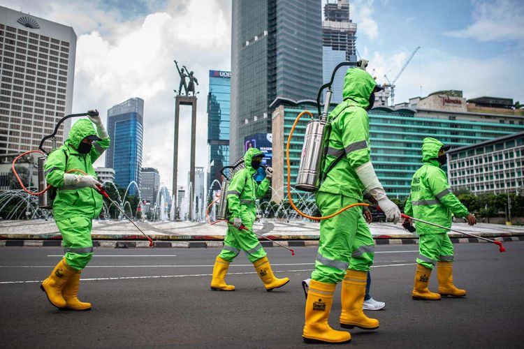 Petugas bersiap menyemprotkan cairan disinfektan di kawasan Bundaran HI, Jakarta, Minggu (22/3/2020). Pemprov DKI Jakarta melakukan penyemprotan fasilitas umum menggunakan cairan disinfektan di lima wilayah DKI Jakarta untuk mencegah penyebaran virus Corona atau COVID-19.