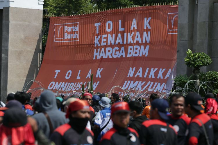 Massa dari elemen buruh melakukan demonstrasi di depan gedung DPR/MPR RI, Jakarta, Selasa (6/9/2022). Mereka memasang spanduk berukuran besar hingga menutupi gerbang masuk utama kompleks parlemen untuk menolak kenaikan harga BBM.