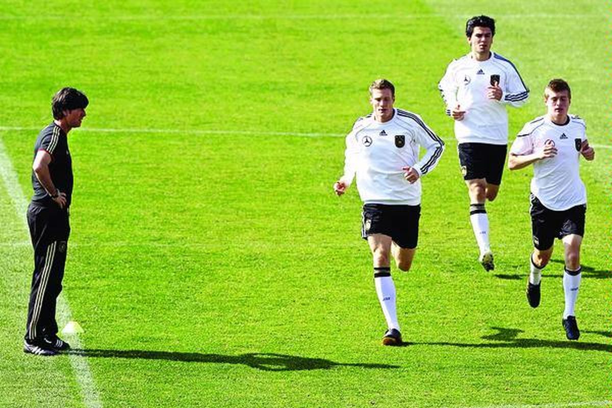 Joachim Loew mengawasi pemainnyayang tengah berlari dari kiri ke kanan, Marcell Jansen, Serdar Tasci, dan Toni Kroos, ketika tim Jerman berlatih di Stadion Super, Atteridg eville, dekat Pretoria, Kamis (1/7). Jerman akan menghadapi Argentina di perempat final Piala Dunia, Sabtu (3/7).
