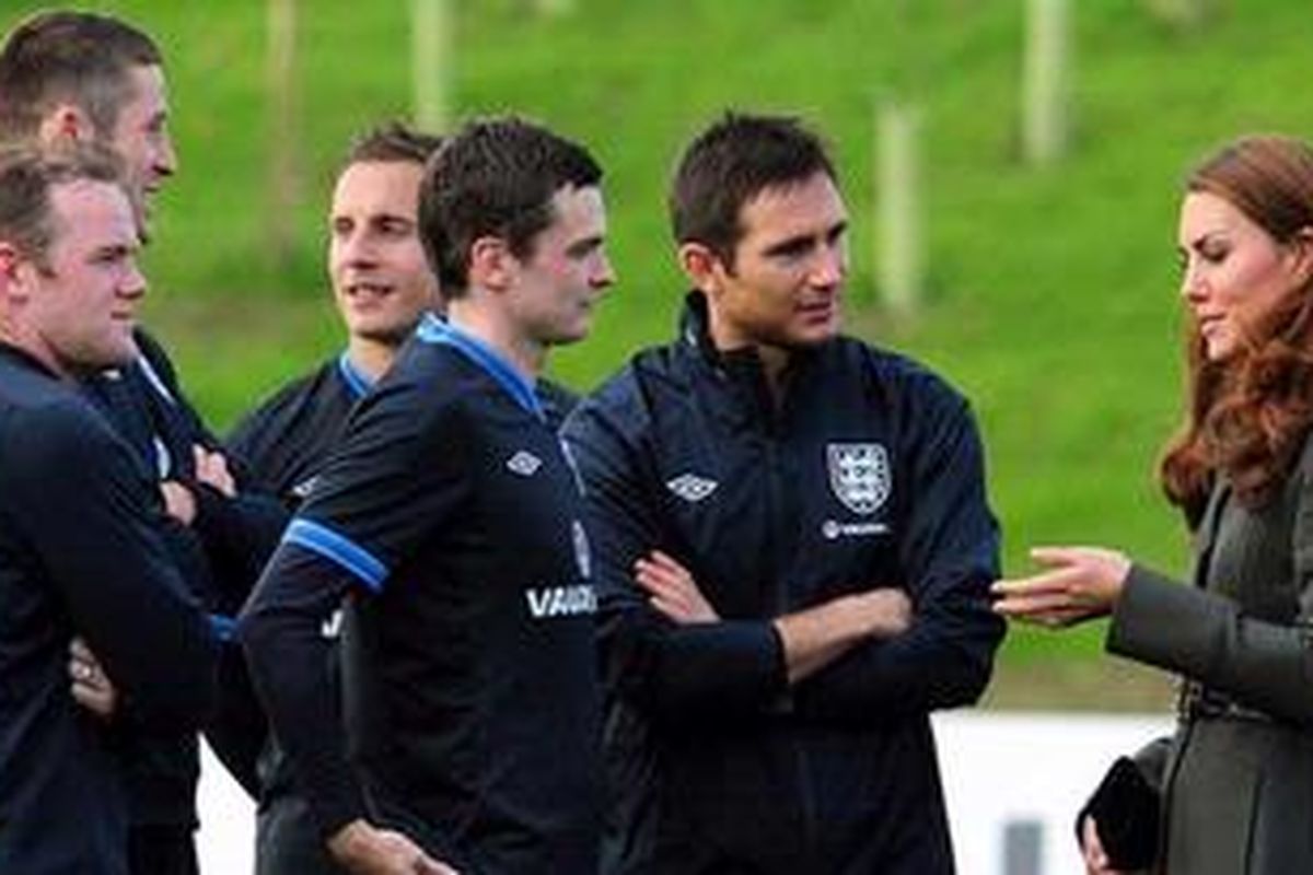 Catherine the Duchess of Cambridge (kanan) atau yang lebih kondang dengan nama Kate Middleton, istri Pangeran William, berbicara dengan beberapa pemain timnas Inggris, Adam Johnson (ketiga dari kanan) dan Frank Lampard (kedua dari kanan), sementara rekan senegaranya, Wayne Rooney (kiri), Gary Cahill (kedua dari kiri), dan Phil Jagielka memperhatikan saat peresmian Pusat Sepak Bola Nasional FA di St Georges Park, Selasa (9/10/2012). 
