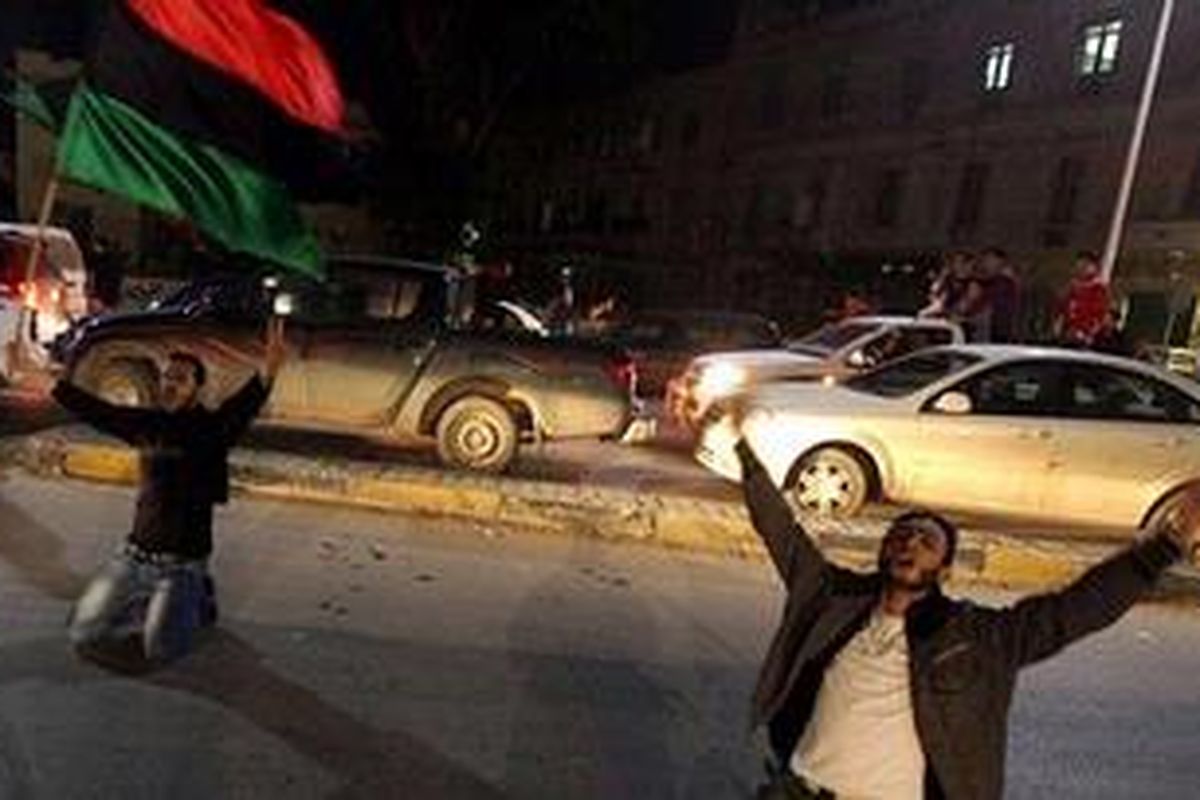 Dua pria ini berlutut di jalan kota Benghazi, Libya, untuk mengungkapkan kesenangan mereka saat berita tentang zona larangan terbang menyebar di negara itu.