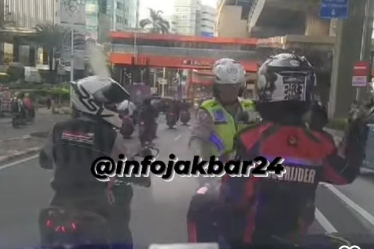 Seorang polisi memberhentikan motor relawan pengawal ambulans saat melakukan pengawalan di Jalan Rasuna Said, Kuningan, Jakarta Selatan, Senin (11/12/2023).