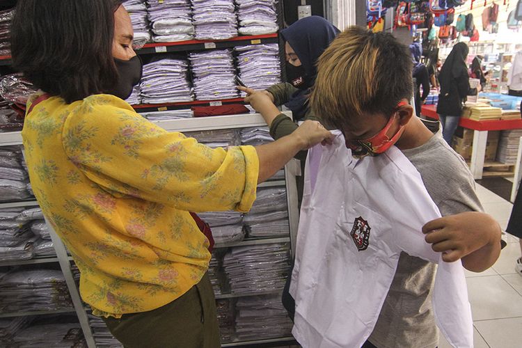 Seorang anak mencoba seragam sekolah di salah satu toko seragam di Pancoran Mas, Depok, Jawa Barat, Sabtu (11/7/2020). Menjelang memasuki tahun ajaran baru 2020/2021, para orang tua sibuk membeli  seragam sekolah. ANTARA FOTO/Asprilla Dwi Adha/hp.