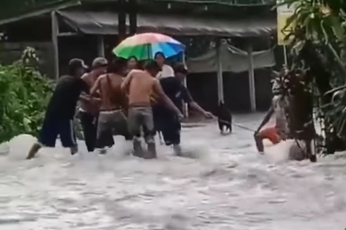 Warga saat mencoba menyelamatkan harta bendanya yang terseret banjir.