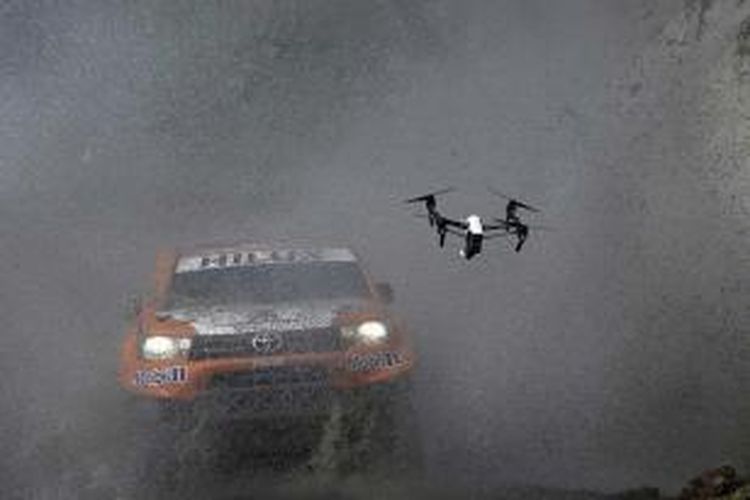 Sebuah drone berada di dekat mobil pereli Toyota asal Perancis Ronan Chabot dan navigator Gilles Pillot saat prolog 11 kilometer Reli Dakar, di Provinsi Buenos Aires, 2 Januari 2016. Ajang balap secara resmi dimulai 3 Januari, pereli akan melintasi wilayah Argentina dan Bolivia selama 2 minggu.