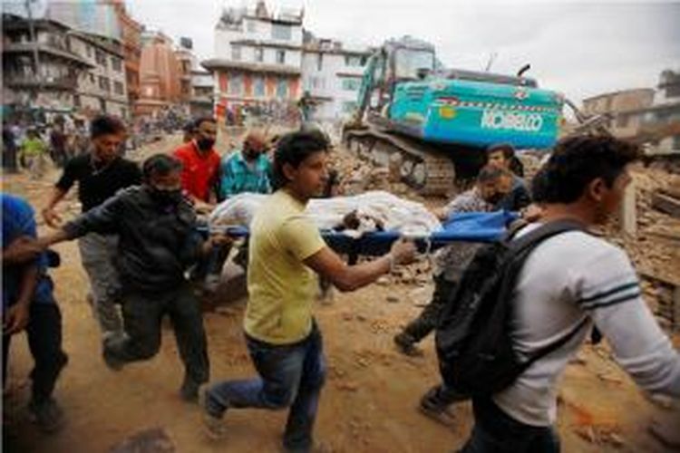 Warga membawa korban gempa yang ditemukan di antara puing-puing bangunan yang ambruk di Kathmandu, Nepal akibat gempa 7,9 Skala Richter (SR) yang mengguncang Sabtu (25/4/2015).