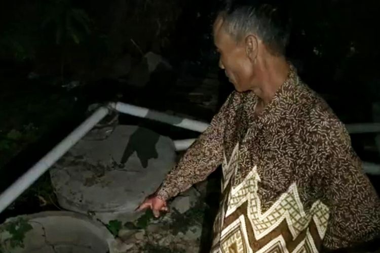 Seorang warga menunjukan lokasi dimana korban pembunuhan dibuang ke dalam septic tank usai dibunuh oleh anak kandung korban di Desa Kendayakan, Warureja, Tegal, Jawa Tengah, Rabu (30/10/2019) dini hari.
