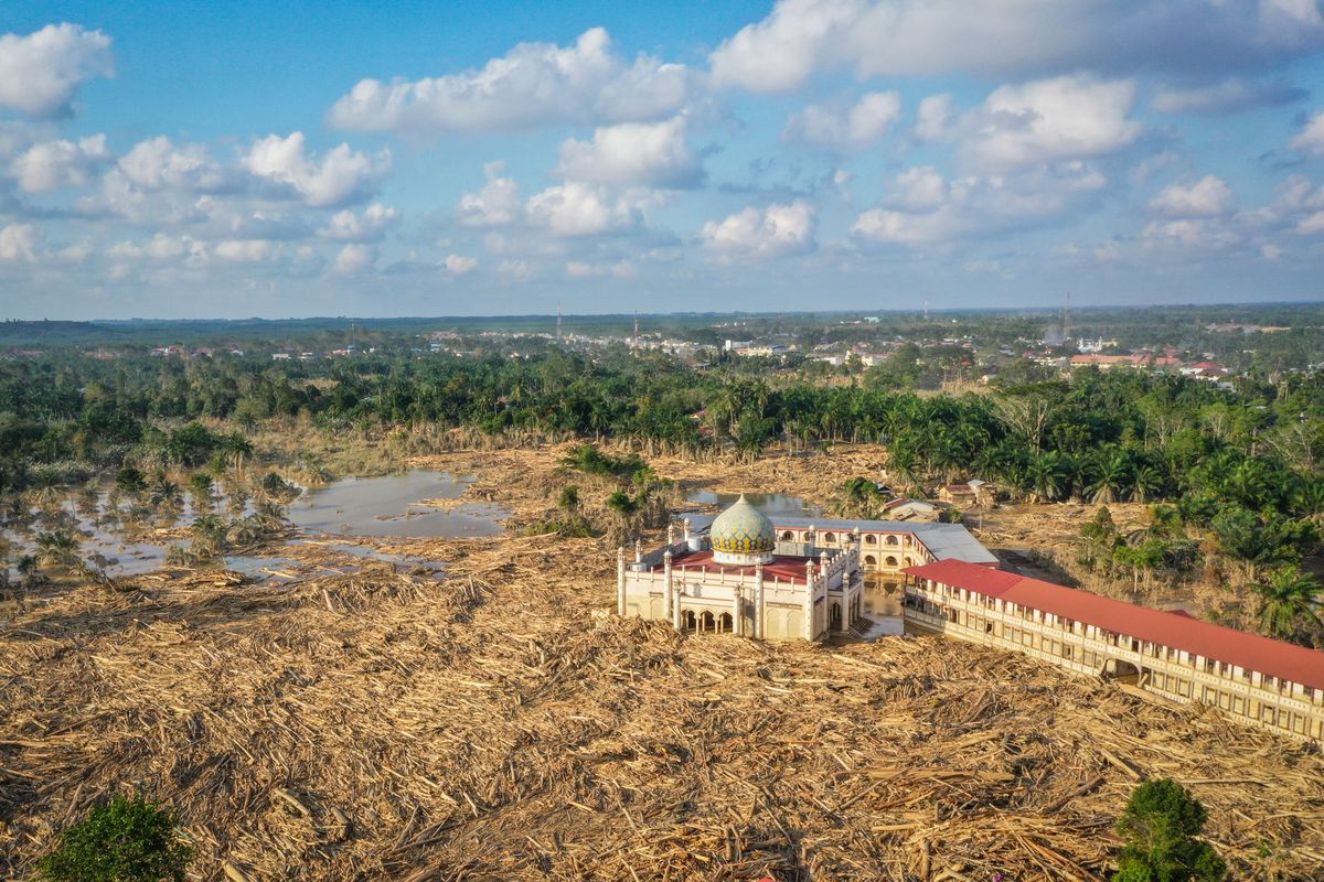 Foto udara menampilkan tumpukan kayu-kayu memenuhi area Pondok Pesantren Darul Mukhlishin pascabanjir bandang di  Desa Tanjung Karang, Karang Baru, Kabupaten Aceh Tamiang, Aceh, Jumat (5/12/2025). Aceh Tamiang Disebut Kota Zombie usai Banjir, Ini 5 Fakta Kondisinya