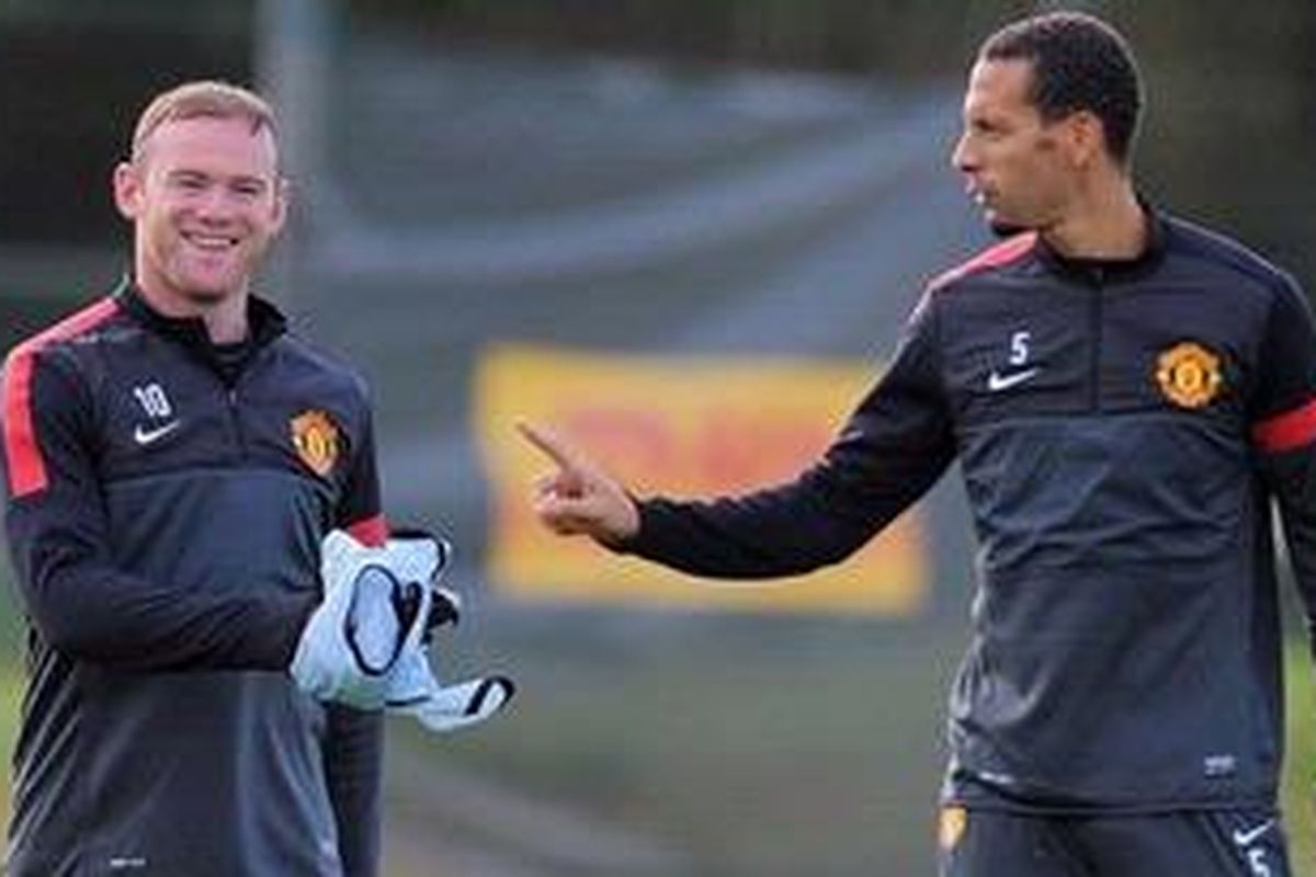 Bomber Manchester United dari Inggris, Wayne Rooney (kiri) dan rekannya bek Rio Ferdinand tengah menjalani sesi latihan tim di pusat latihan MU di Carrington, pada 1 Oktober 2012, jelang pertandingan penyisihan Grup H Liga Champions melawan CFR Cluj.