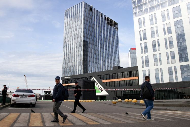 Seorang petugas polisi mengamankan area di depan pusat bisnis yang rusak di Jalan Likhacheva setelah serangan drone di Moskwa, Rusia pada 24 Juli 2023. 