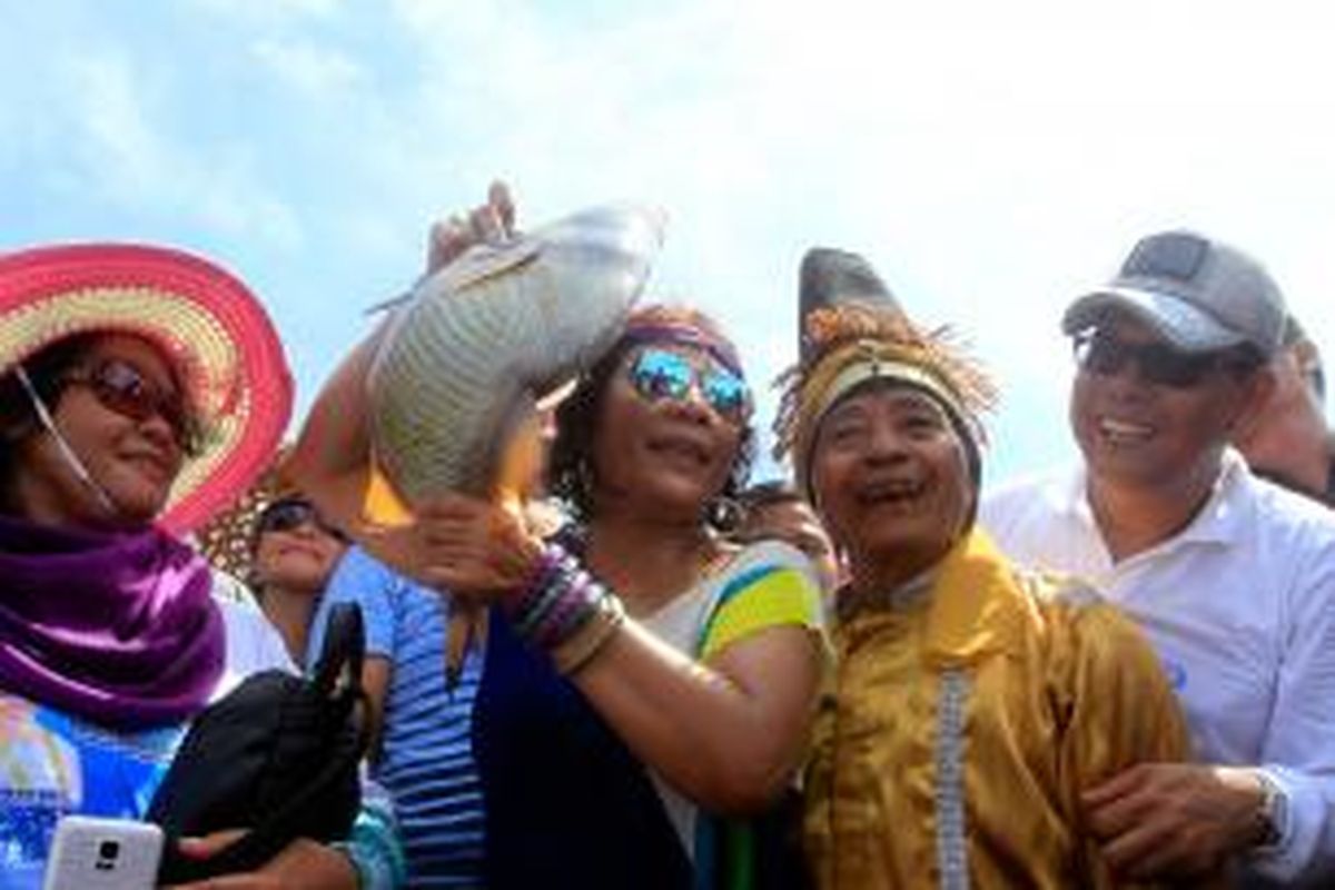Menteri Kelautan dan Perikanan Susi Pujiastuti memperlihatkan ikan yang baru saja ditangkapnya saat menghadiri Festival Mane'e di Pulau Intata, Kecamatan Nanusa, Kabupaten Talaud, Sulawesi Utara, Kamis (7/5/2015). 