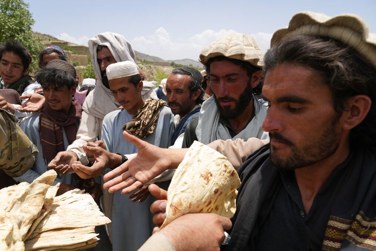 Warga Afghanistan menerima bantuan di sebuah kamp setelah gempa bumi di distrik Gayan di provinsi Paktika, Afghanistan, Minggu, 26 Juni 2022.