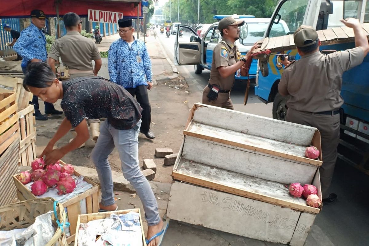 Petugas Satpol PP Jakarta Timur saat menertibkan sejumlah Pedagang Kaki Lima (PKL) yang keberadaannya kerap mengganggu arus lalu lintas di Jalan Raya Bogor, Jakarta Timur, Senin (28/10/2019).