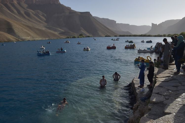 Dalam foto yang diambil pada 14 Juli 2022 ini, para turis Afghanistan menyejukkan diri dan menikmati perjalanan dengan perahu di Danau Ban e-Amir di provinsi Bamiyan. Taliban kini melarang perempuan berkunjung ke danau tersebut.