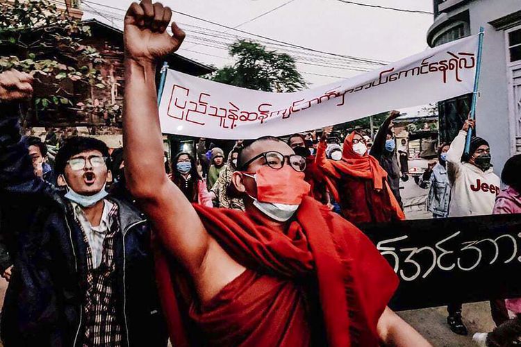 Seorang biksu Buddha mengacungkan tinjunya saat menggelar aksi selama demonstrasi anti-junta militer Myanmar pada Selasa (1/2/2022) di Mandalay, Myanmar. Pada Kamis (1/12/2022), sedikitnya 2.000 pejuang pro-demokrasi Myanmar disebut tewas dalam memerangi junta militer yang merebut kekuasaan tahun lalu.