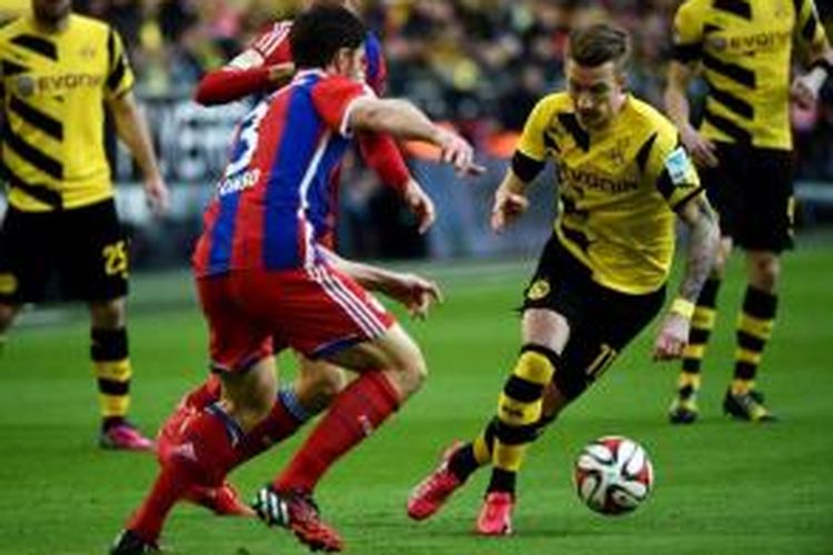 Gelandang Borussia Dortmund, Marco Reus (kanan), mencoba melewati hadangan gelandang Bayern Muenchen, Xabi Alonso, pada laga Bundesliga di Stadion Signal Iduna Park, Dortmund, Sabtu (4/4/2015).