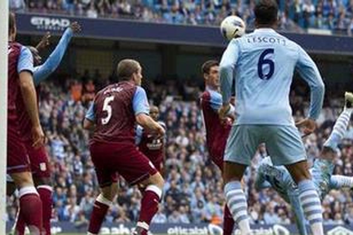 Penyerang Manchester City, Mario Balotelli (kanan), menyambut bola liar dengan 