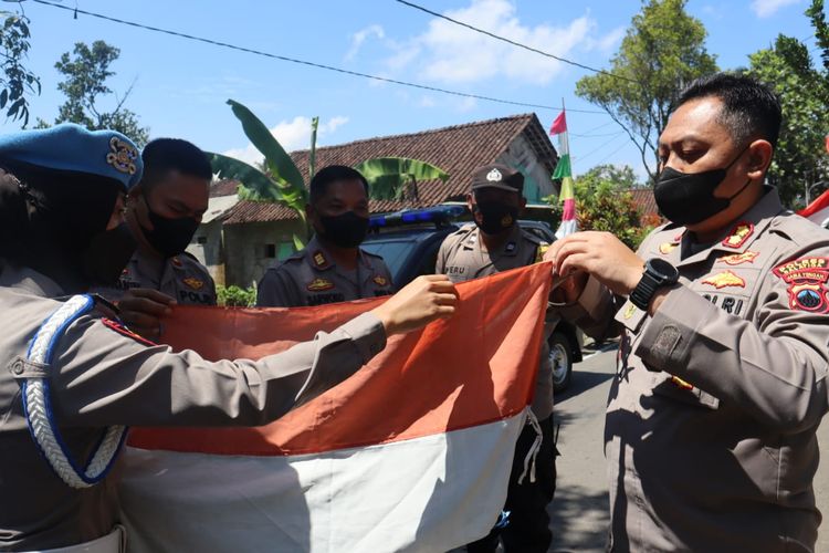 Kapolres Salatiga AKBP Indra Mardiana mengganti bendera lusuh milik warga.