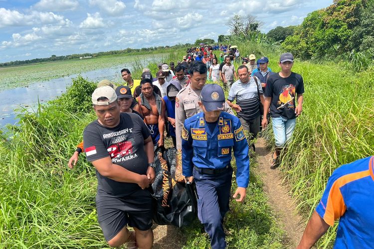 Petugas membawa jasad pemancing asal Kediri yang ditemukan tewas usai tenggelam di waduk yang berada di Desa Rancang Kencono, Kecamatan/Kabupaten Lamongan, Jawa Timur, Minggu (8/1/2023).