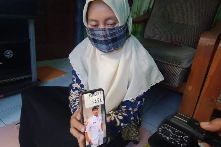 Helen menunjukkan foto suaminya, Serda Diyut yang tercatat sebagai salah satu ABK KRI Nanggala-402 yang hilang di perairan sekitar 60 mil laut utara Pulau Bali, Rabu (21-4-2021) dini hari, di rumahnya Kota Madiun, Jatim, Kamis (22-4-2021). 