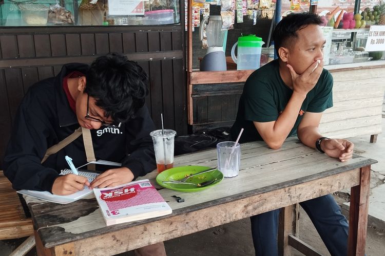 Dua pelajar bahasa mandarin di Kampung Inggris Kecamatan Pare, Kabupaten Kediri, Jawa Timur, tengah belajar di sela-sela istrahat siangnya, medio Februari 2025.