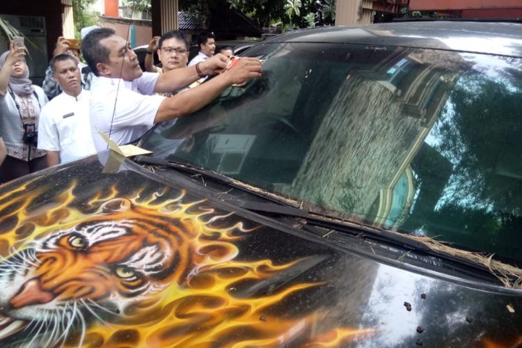 Petugas memasang stiker berisikan imabuan untuk melunasi pajak pada kendaraanToyota Tundra 57 D.CAT di Jalan Cengkareng, Jakarta Barat, Jumat (6/12/2019)  