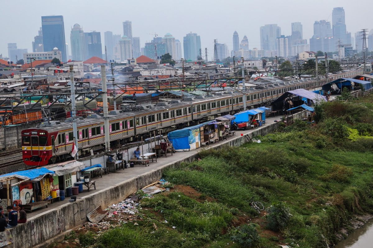 Kereta listrik (KRL) melintas di samping deretan bangunan liar di sepanjang tepi Sungai Ciliwung, Jalan Tenaga Listrik, Tanah Abang, Jakarta Pusat, Sabtu (30/9/2017). Gubuk liar kembali berdiri di sepanjang Sungai Ciliwung akibat kurangnya pengawasan dari Pemprov DKI Jakarta.