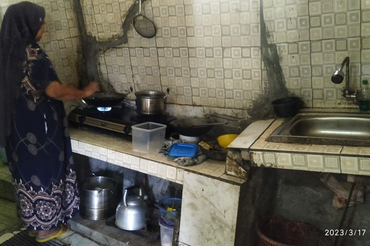 Omah Romlah (45) penyintas bencana gerakan tanah memasak di dapur dengan kondisi rumah yang rusak di Kampung Gunungbatu, Desa Kertaangsana, Nyalindung, Sukabumi, Jawa Barat, Jumat (17/3/2023).