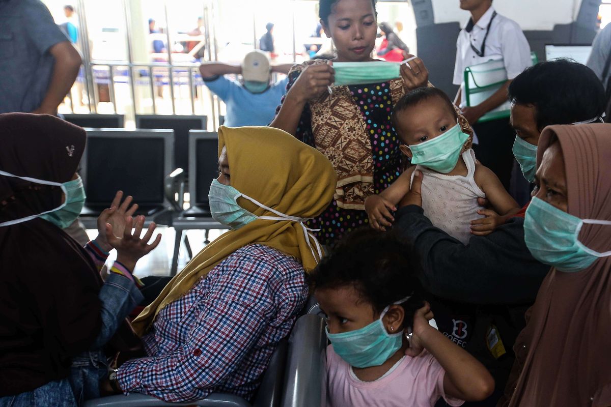 Penumpang menggunakan masker yang dibagikan petugas kesehatan dalam sosialisasi COVID-19 di Stasiun Pasar Senen, Jakarta, Senin (9/3/2020). PT KAI juga menyediakan layanan klinik kesehatan di masing-masing stasiun serta melakukan pengecekan suhu tubuh menggunakan termometer kepada penumpang yang membutuhkan layanan kesehatan.