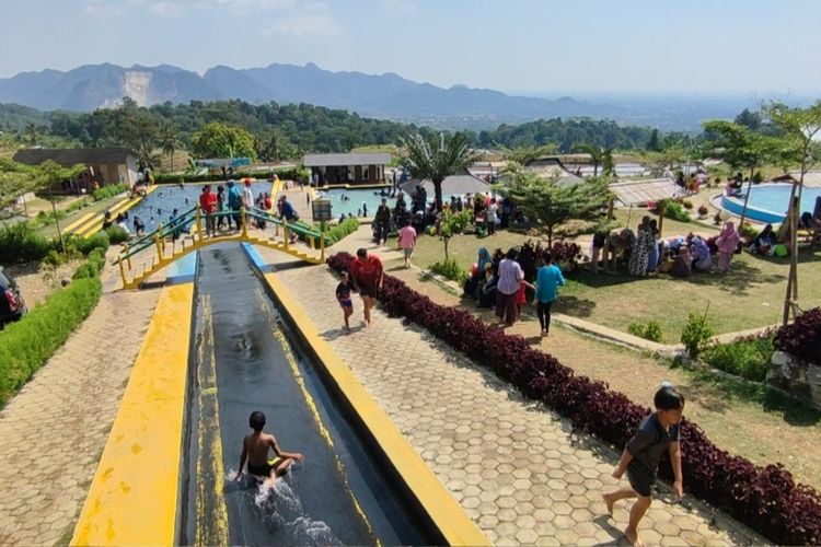 Sejumlah pengunjung menikmati prosotan dan mandi busa di objek wisata Sideland, Desa Kaduela, Kecamatan Pasawahan, Kabupaten Kuningan, Jawa Barat, (1/6/2023).