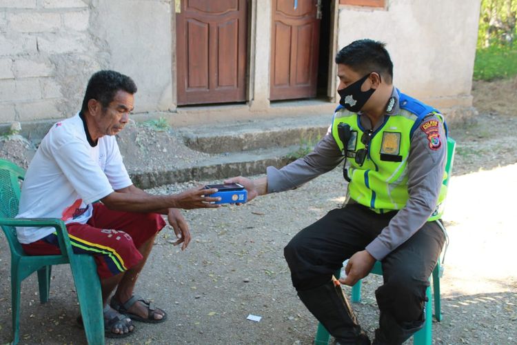 Aloysius Lamanepa (58), warga Desa Penfui Timur, Kecamatan Kupang Tengah, Kabupaten Kupang, NTT, saat menerima bantuan HP dari Bripka Abdul Asis. HP itu akan diberikan untuk anaknya Fortunatus Roland Lamanepa (20), yang digunakan untuk kuliah online